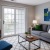 a living room with a tv and couches and a balcony door