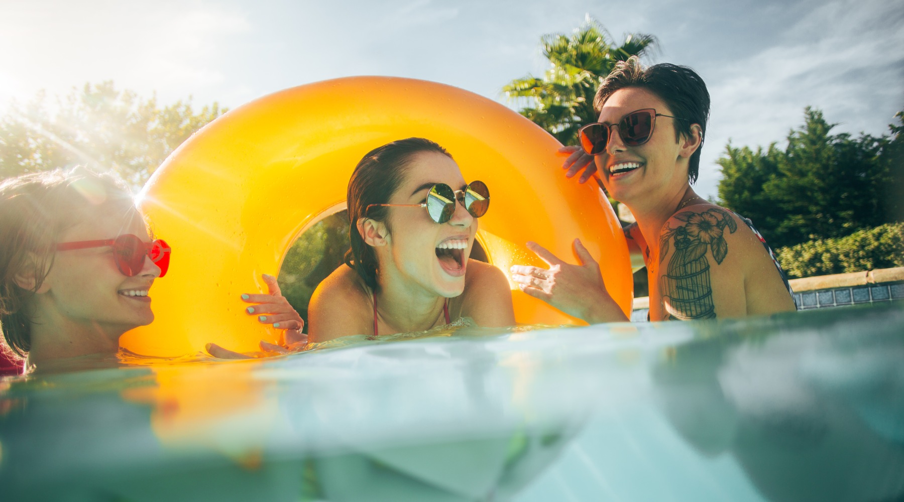 Settle into comfort at Franklin Park Apartments Three women in the pool with round yellow float
